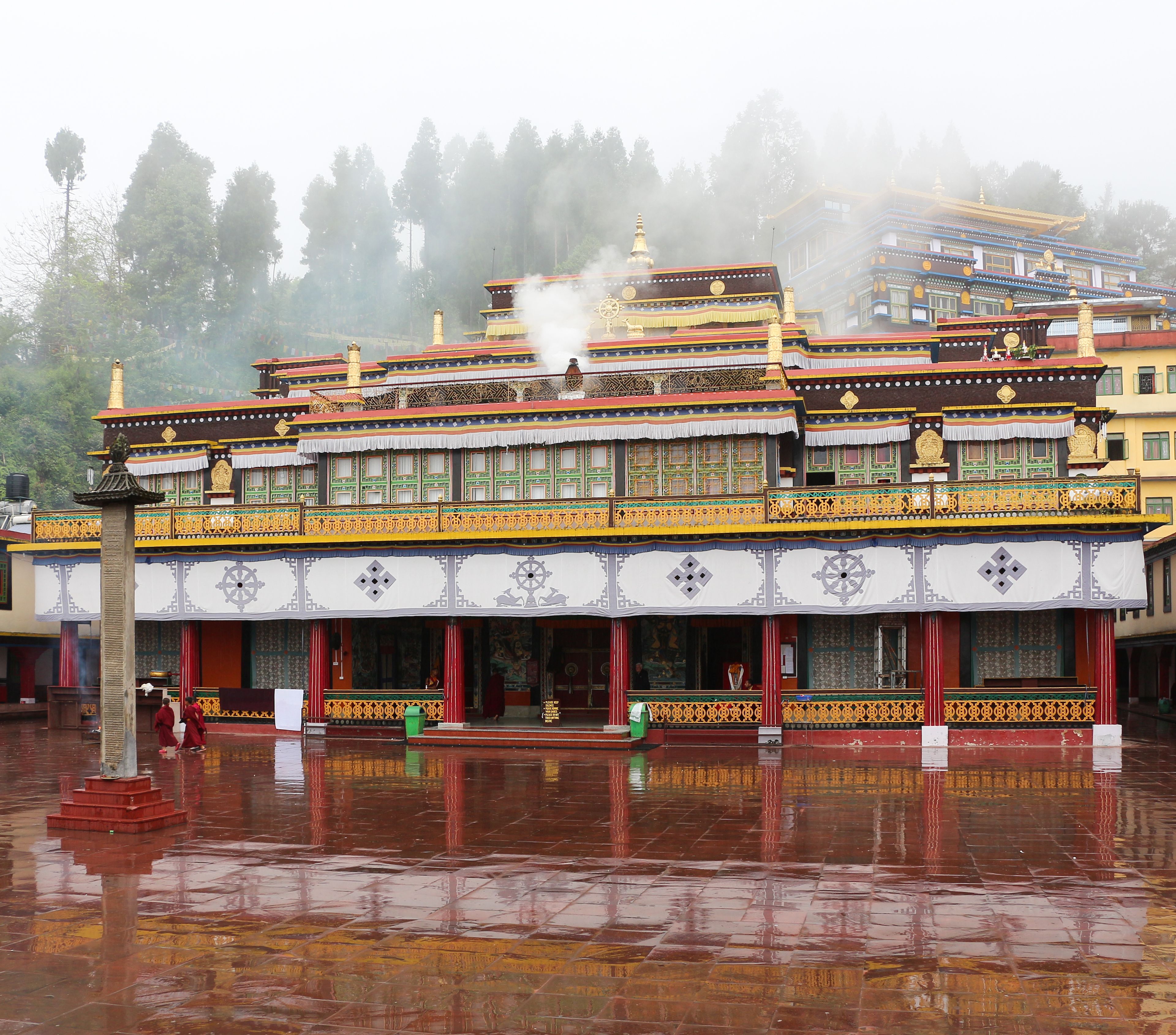 Colourful Rumtek Monastery above a rain-polished courtyard near Gangtok