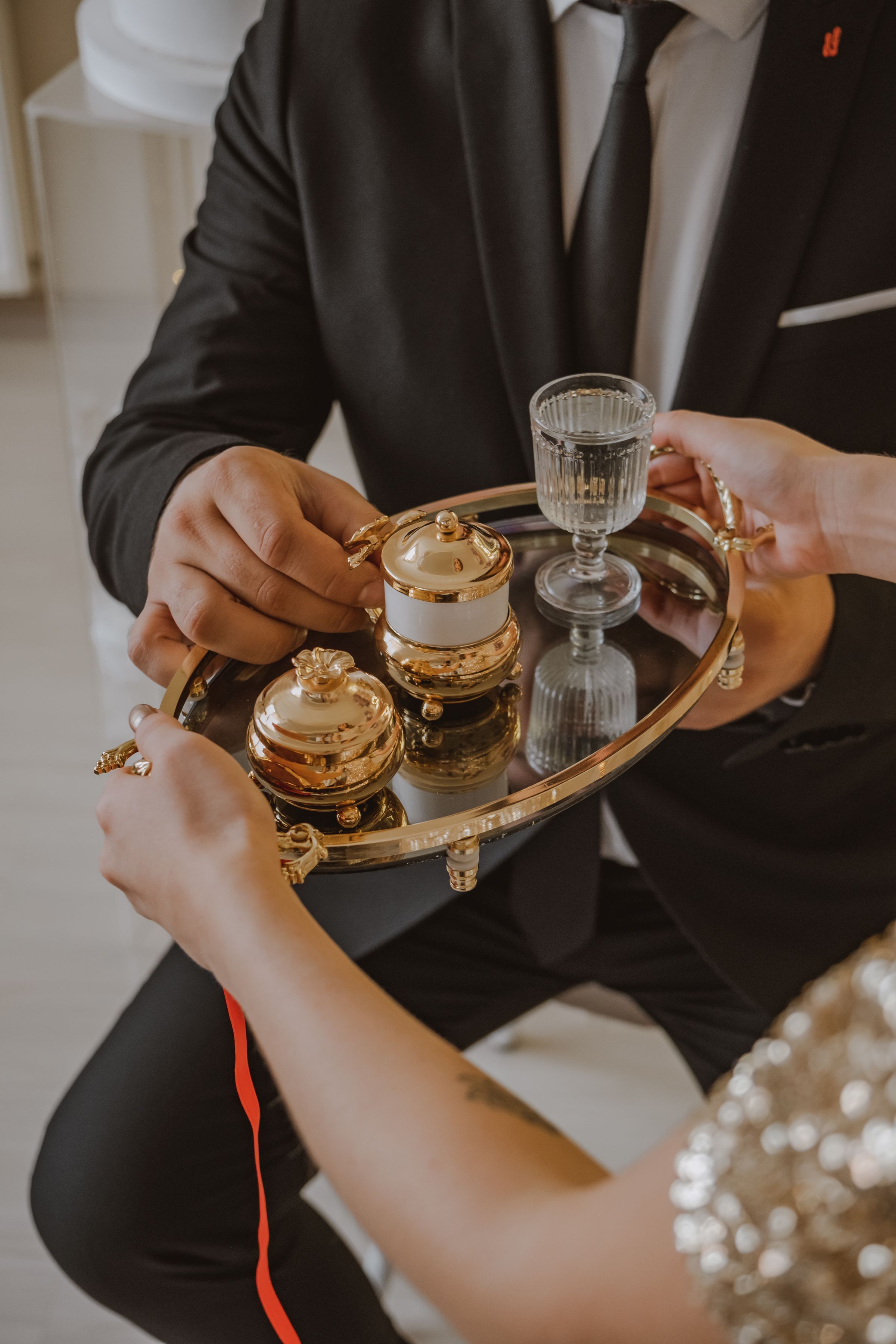 Porcelain cups being served on an ornate silver tray