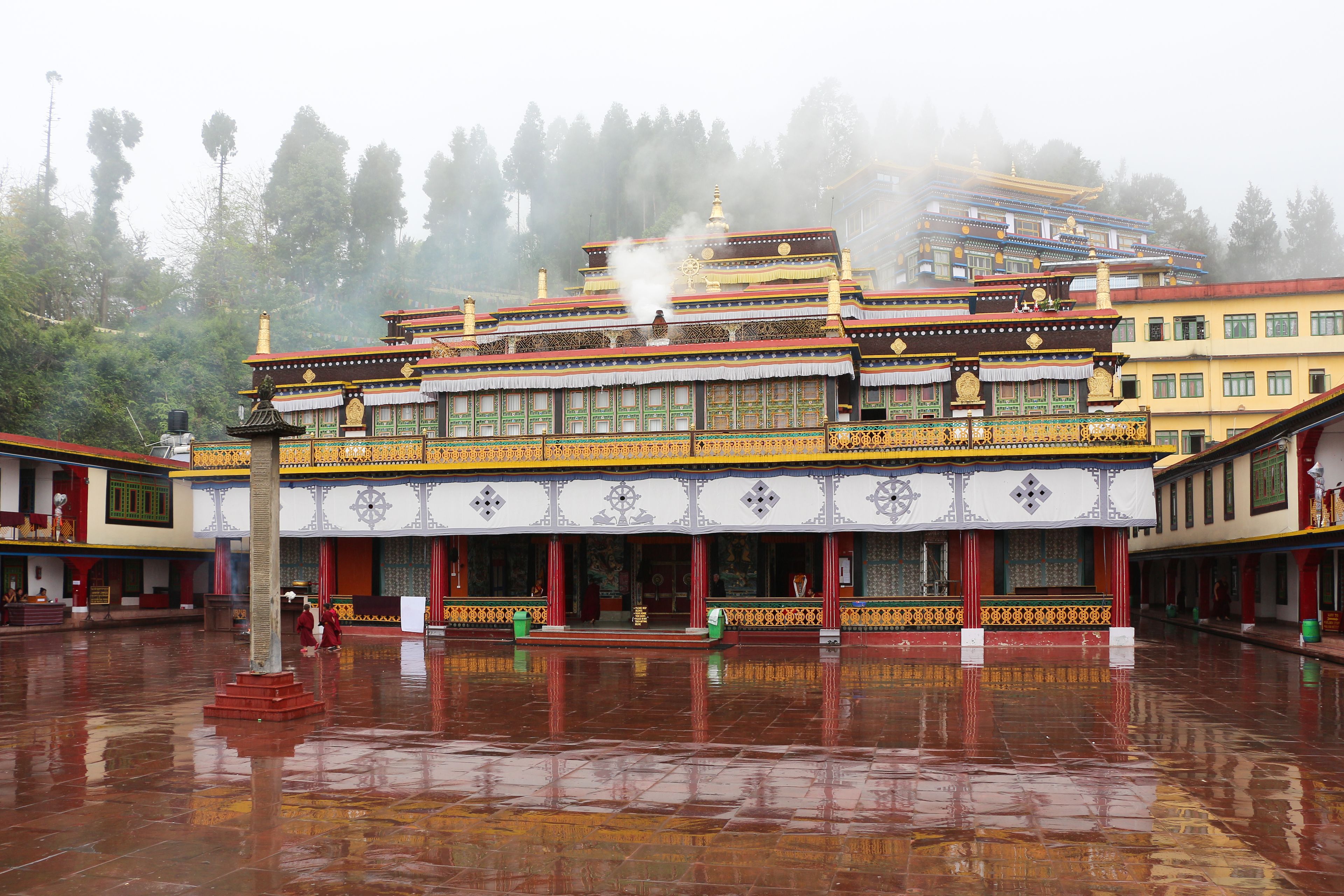 Colourful Rumtek Monastery above a rain-polished courtyard near Gangtok