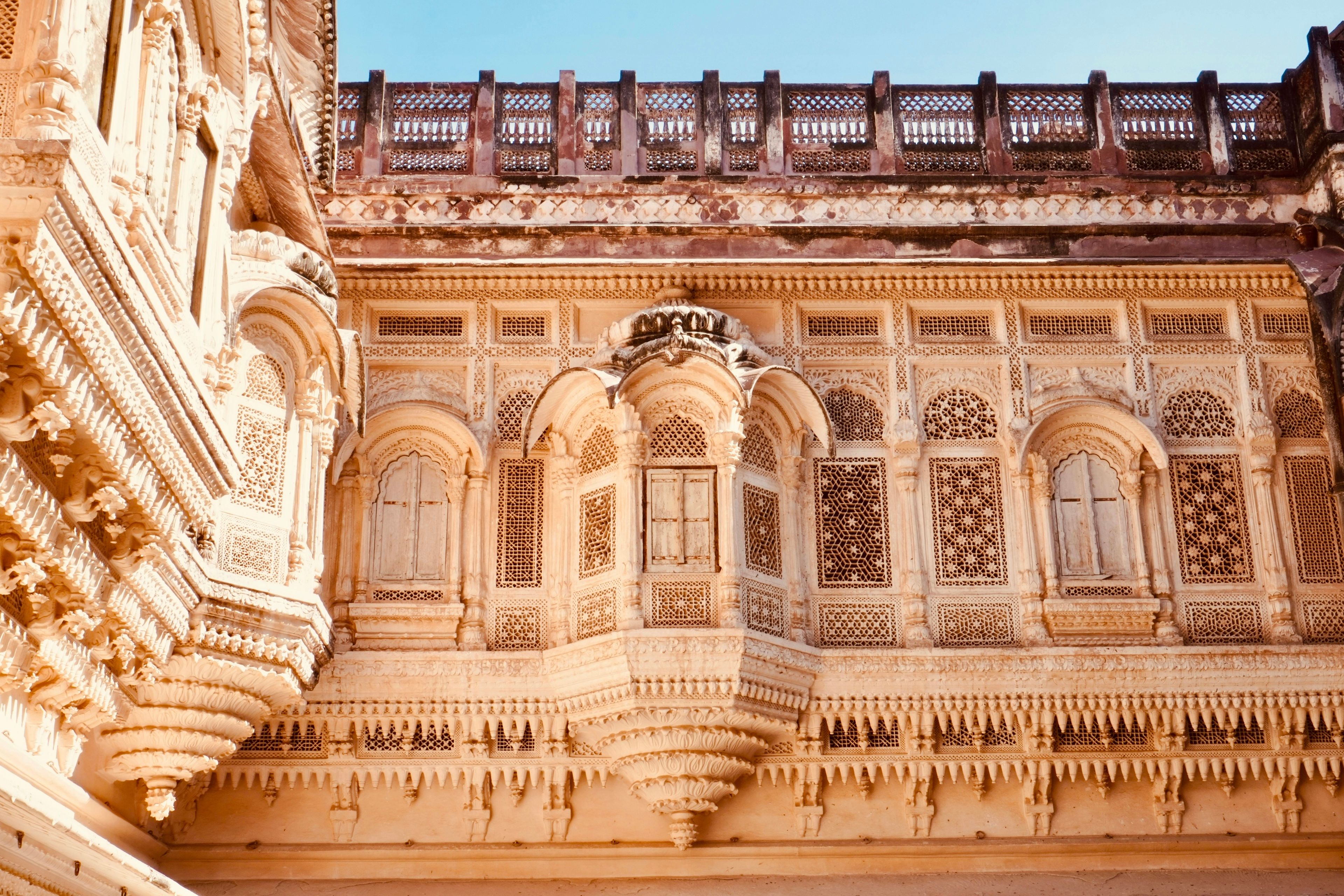 Sunlit carved sandstone balconies and lattice windows inside Mehrangarh Fort in Jodhpur