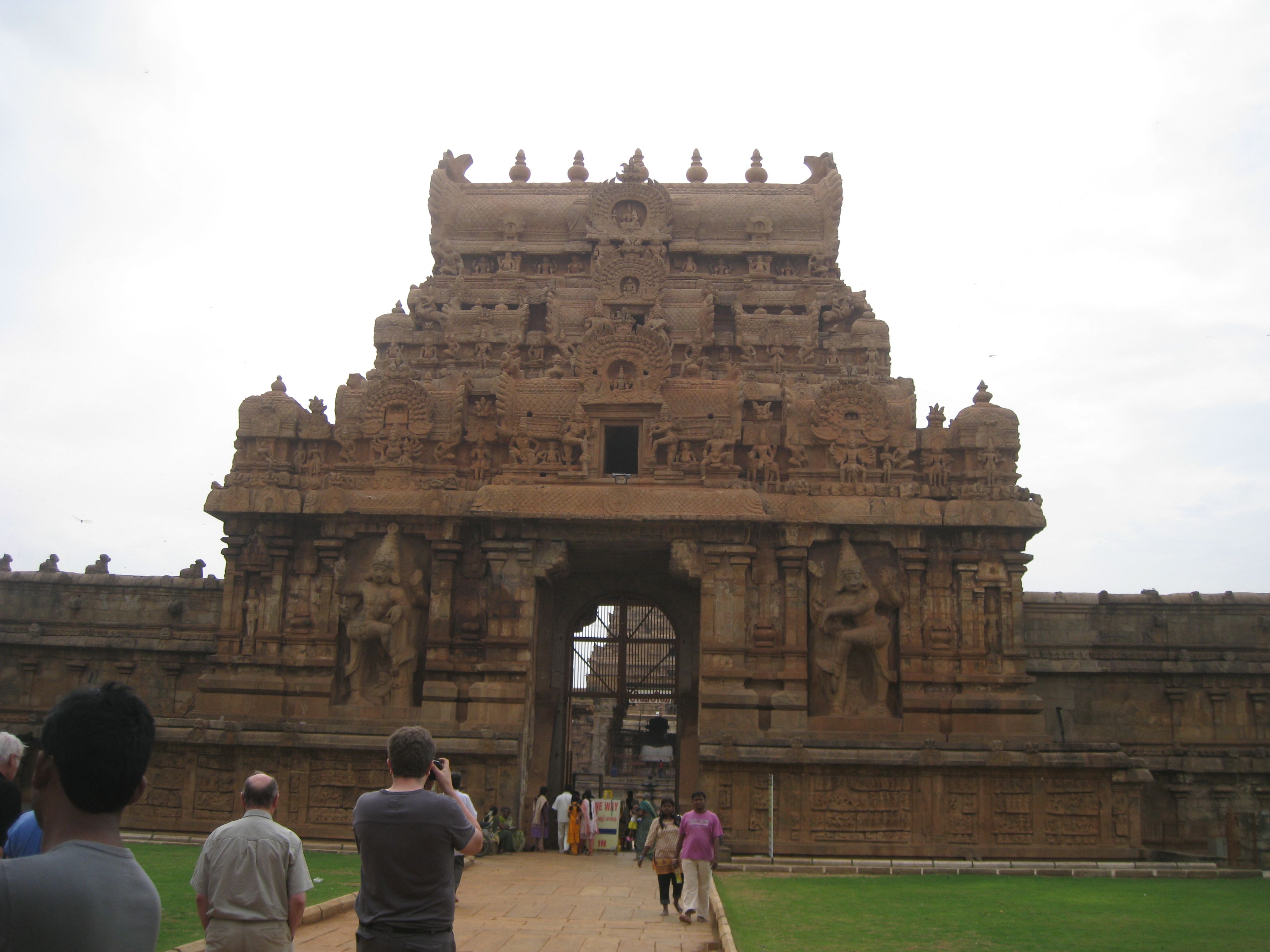Visitors before the carved stone entrance to the Brihadisvara Temple complex in Thanjavur