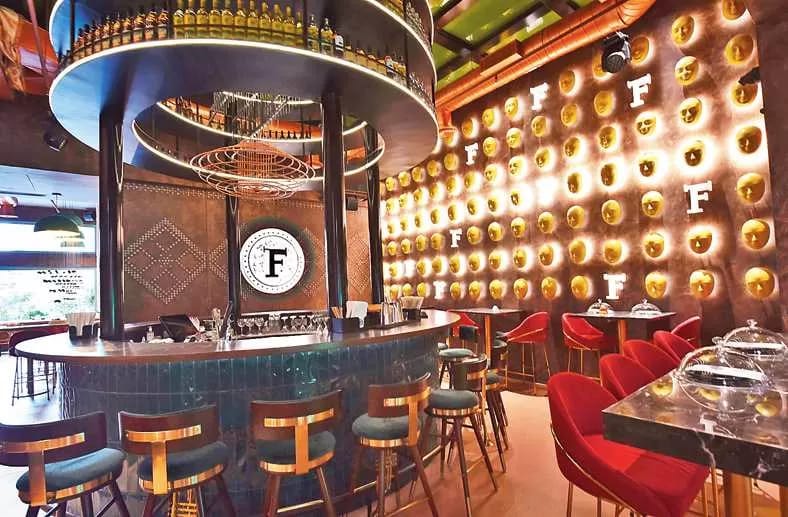 A restaurant dining room with a bar and illuminated wall displays
