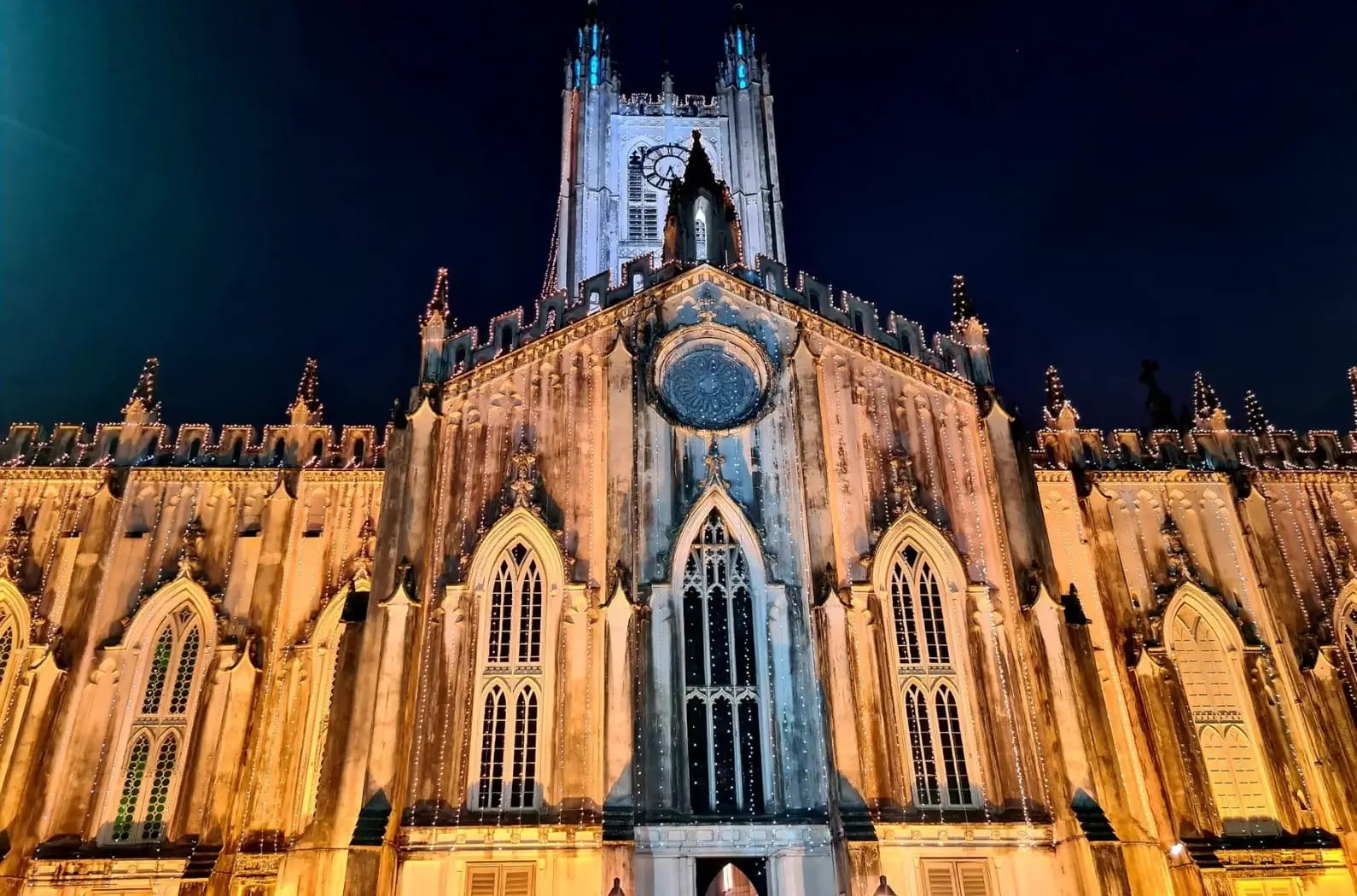 An illuminated cathedral facade beneath a dark sky