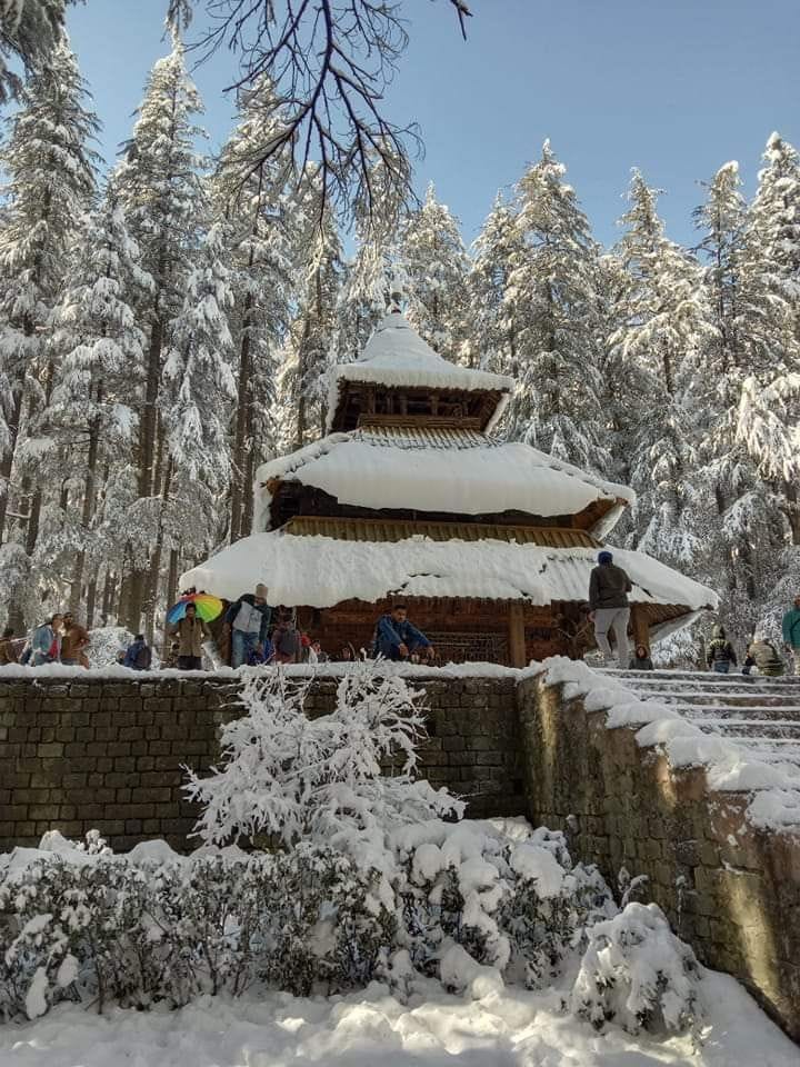 A wooden temple surrounded by snow-covered trees