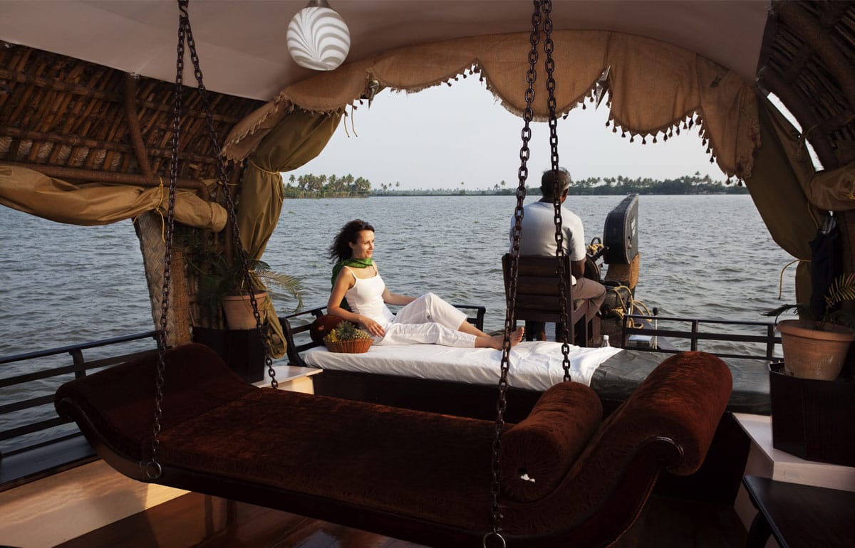 A guest seated beneath a houseboat canopy overlooking the water