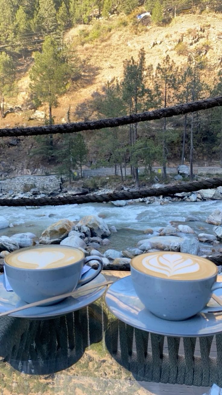 Cups of tea on a balcony overlooking a stream