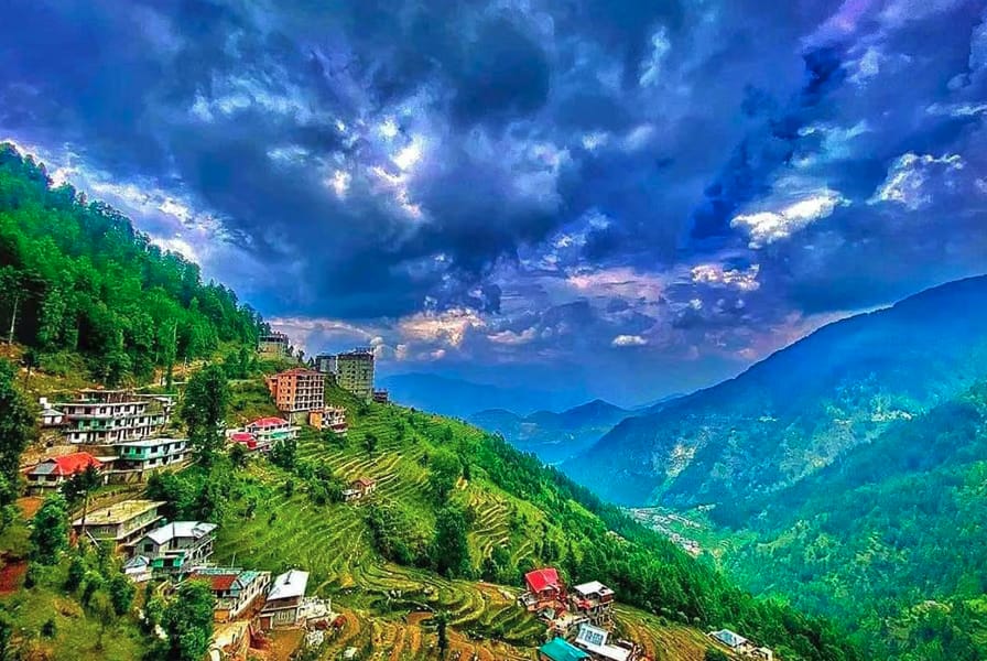 A hillside town above a green mountain valley
