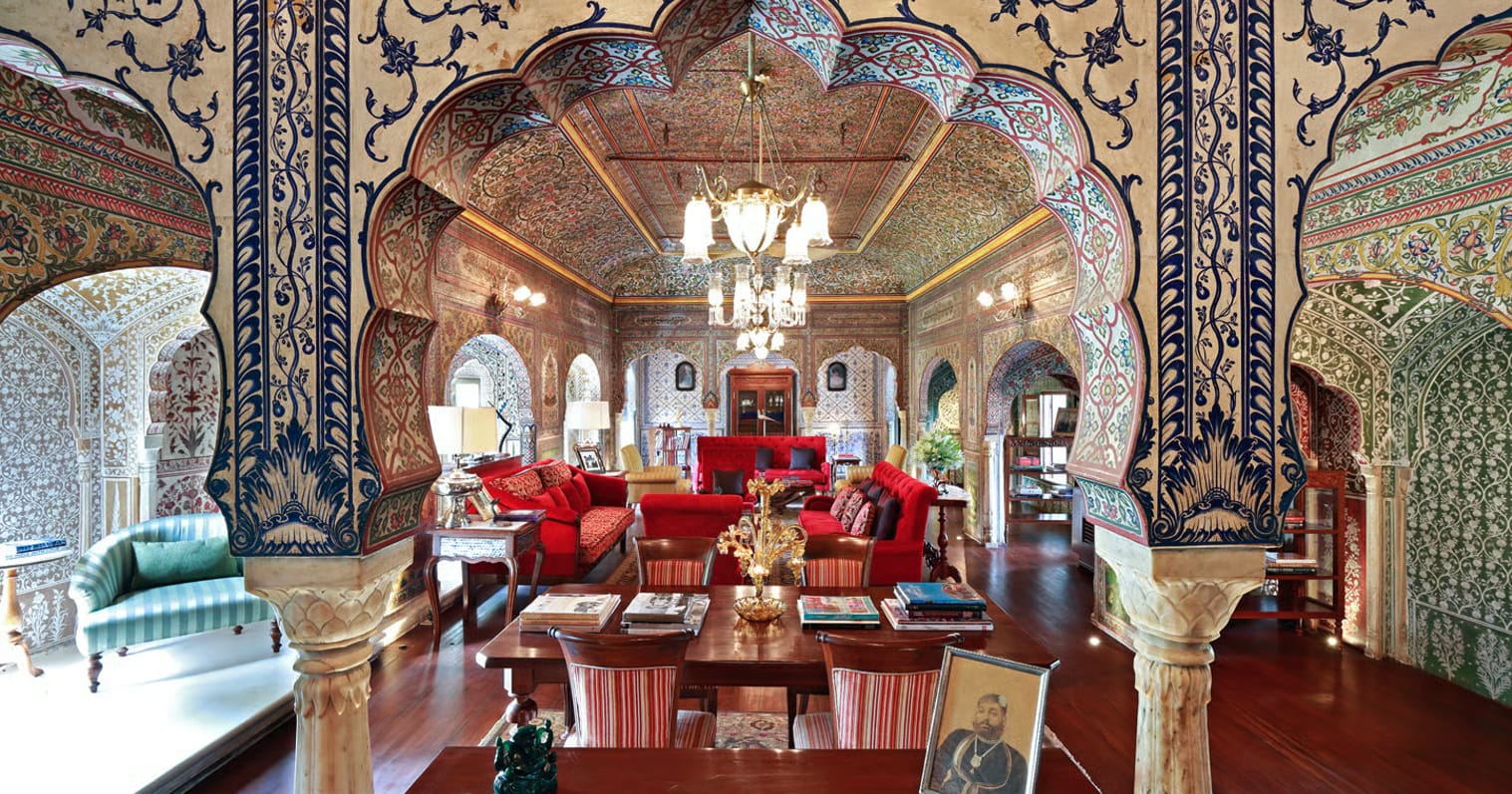 A mirrored dining room with painted arches and chandeliers