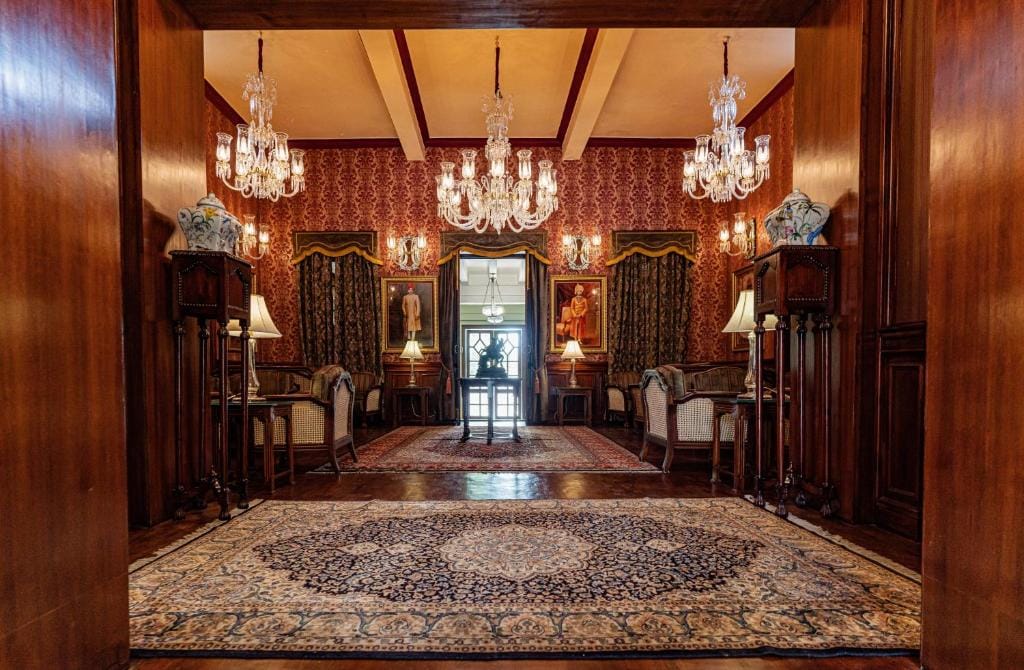 Chandeliers hanging above a richly paneled palace hall