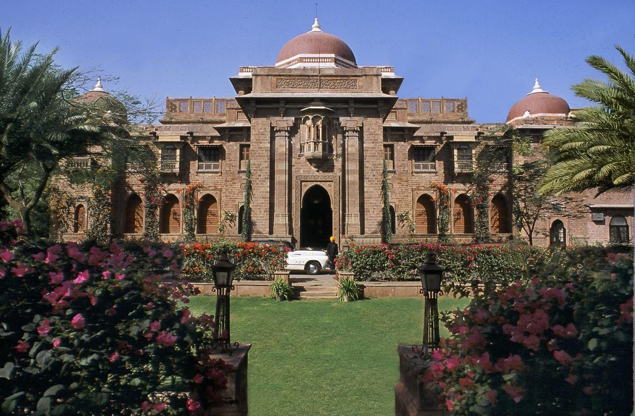A stone palace facade framed by flower beds