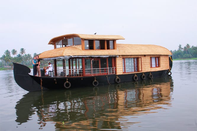 A traditional houseboat reflected in calm backwater