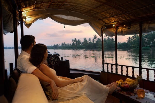 A couple relaxing on a covered houseboat deck