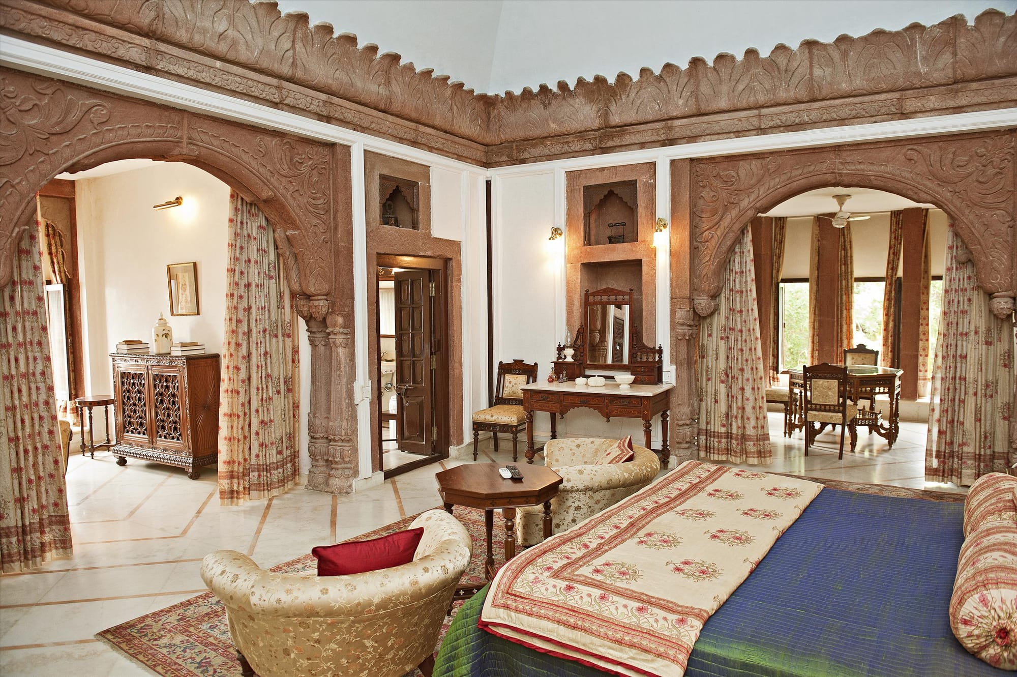 Carved stone arches framing a heritage hotel sitting room