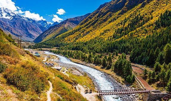 A mountain river winding through trees in autumn colors
