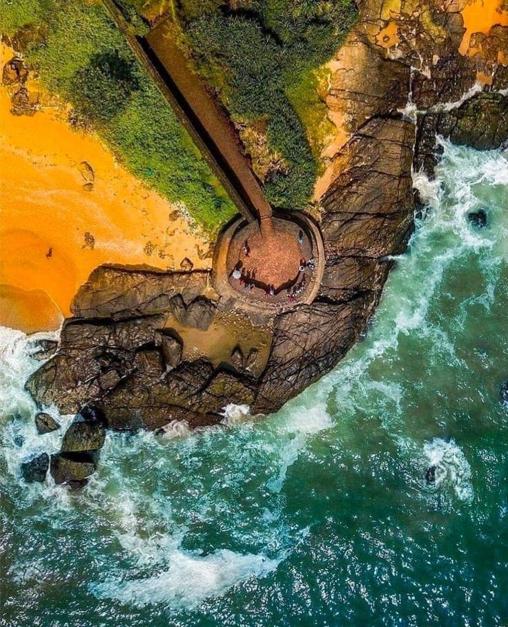 Aerial view of waves beside a circular coastal fort bastion