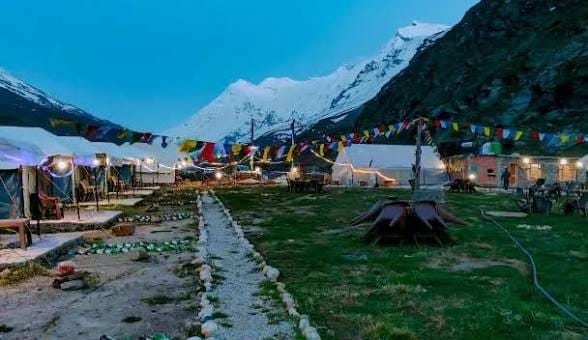 A stone path through a campsite decorated with prayer flags