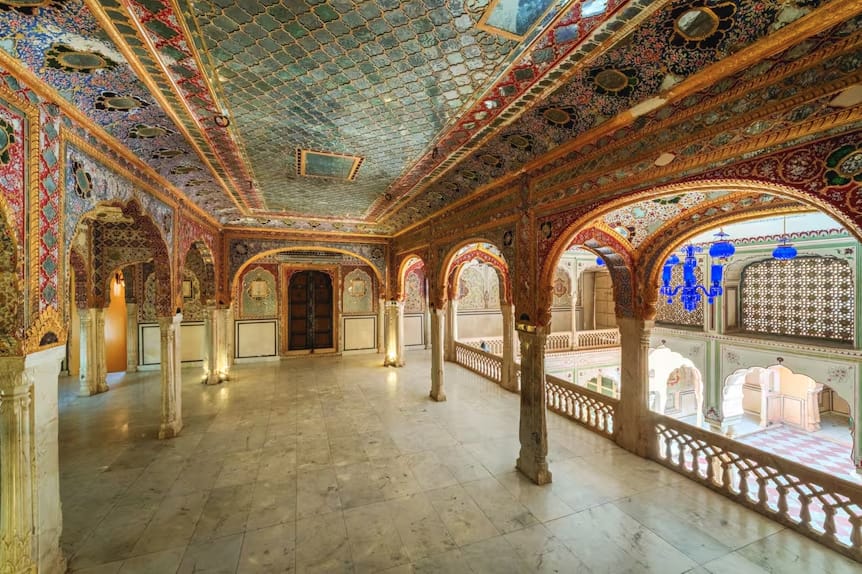 A palace gallery with painted ceilings and stained-glass windows