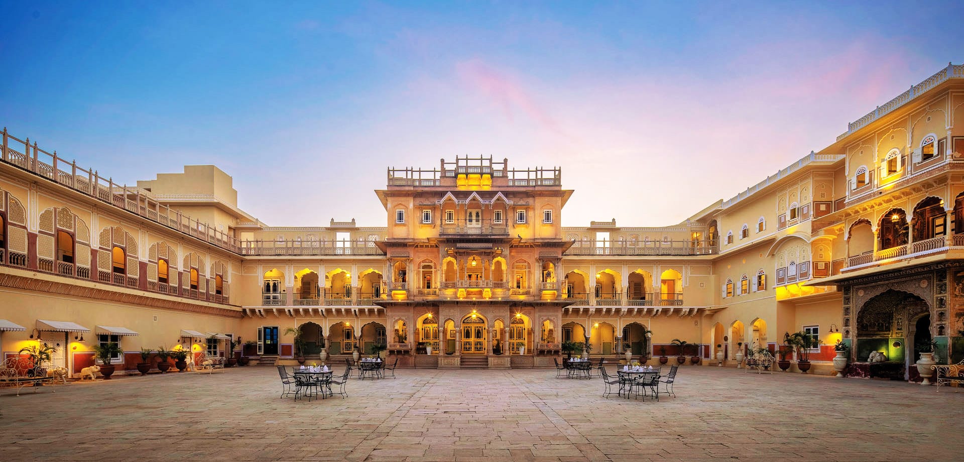 An illuminated palace courtyard with arched balconies