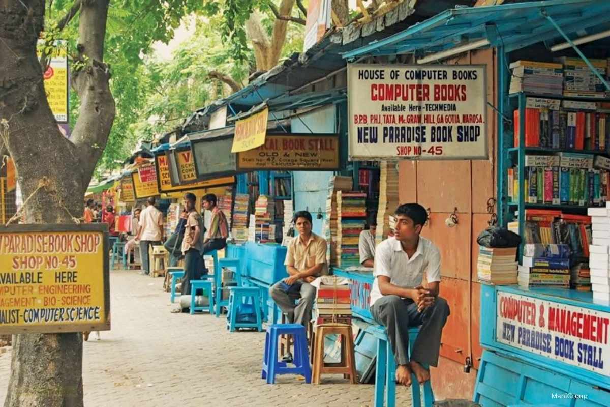 Booksellers and customers beside pavement book stalls