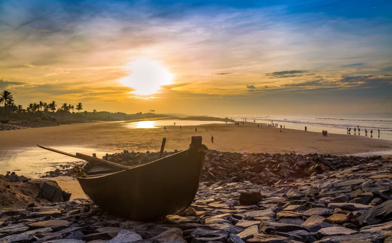 A wooden boat on the shore at sunset