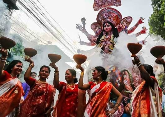 Women carrying clay incense burners during a Durga Puja celebration