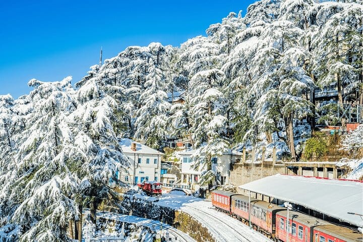 Roadside buildings beneath a snow-covered wooded hillside