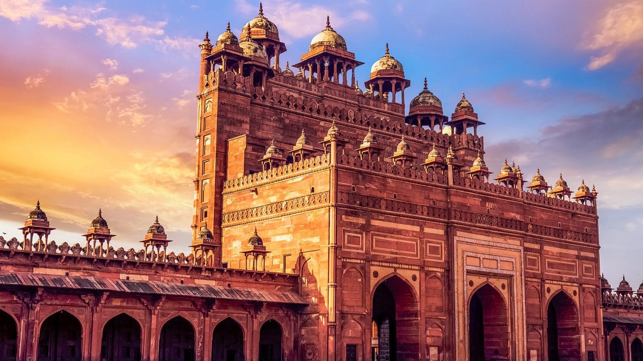 A monumental red sandstone gateway in warm evening light
