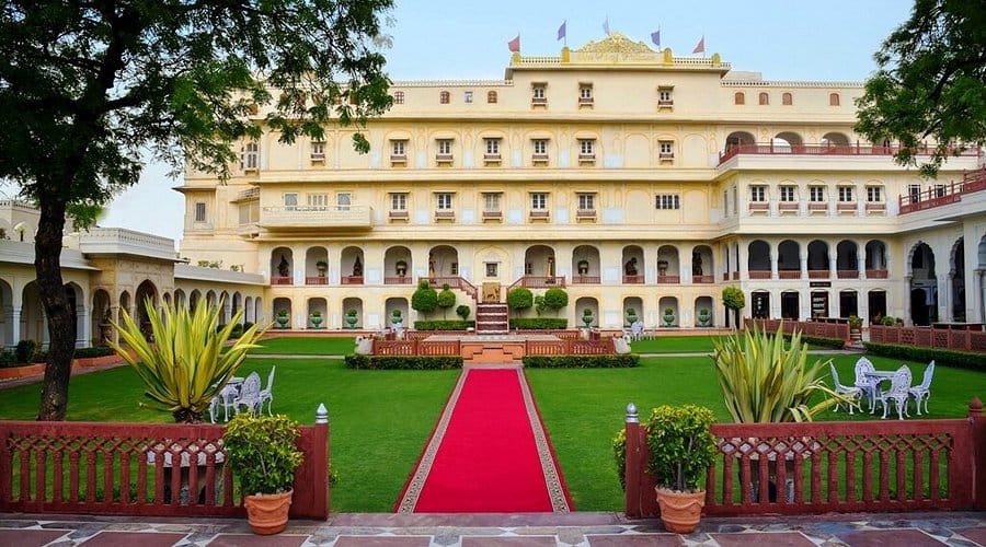 A red carpet leading across a lawn to a heritage hotel