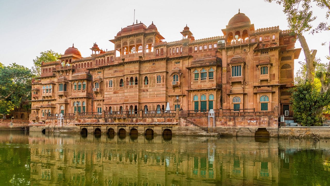 An ornate heritage building reflected in a lake