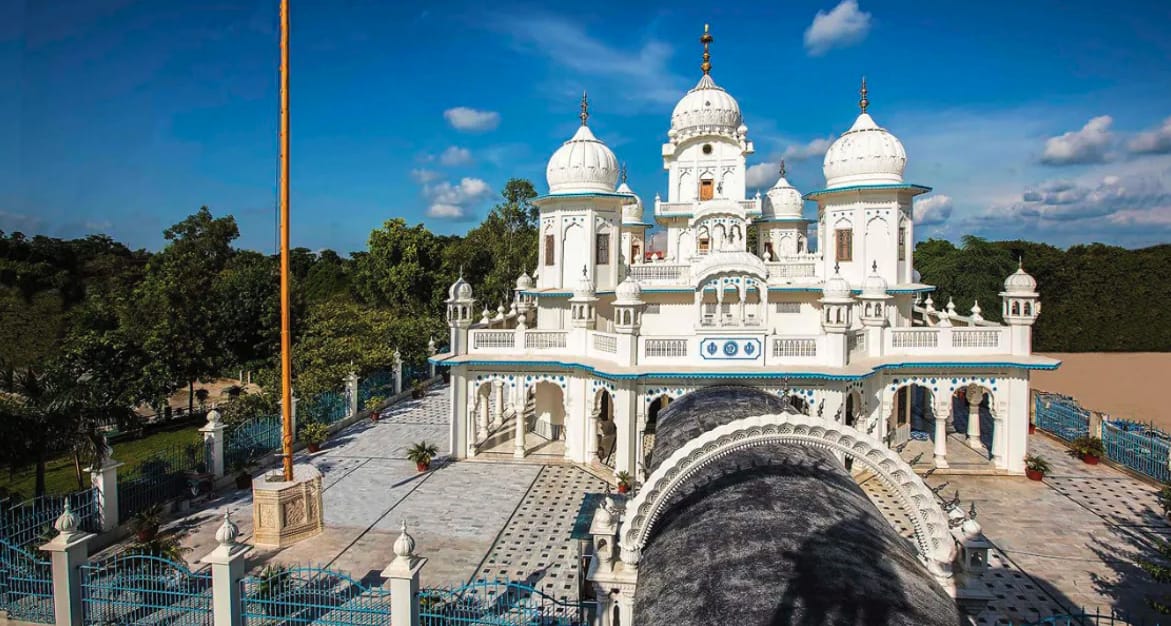 A white domed shrine above a rocky riverbank