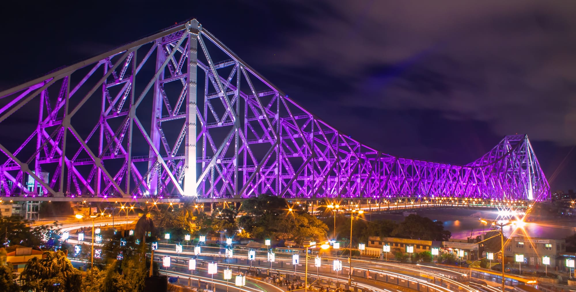 Howrah Bridge illuminated in purple at night