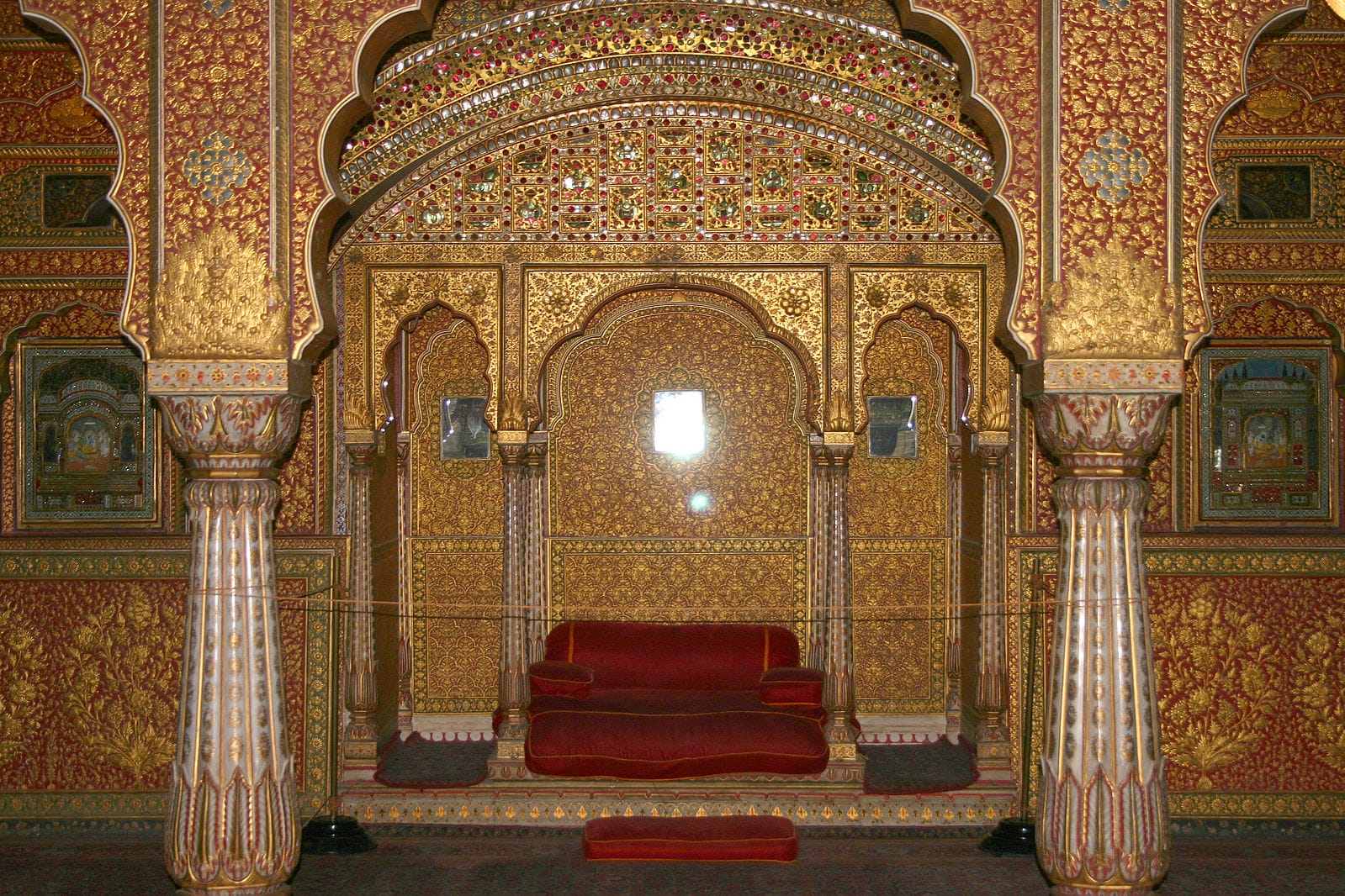 An ornate gilded palace alcove with an arched doorway