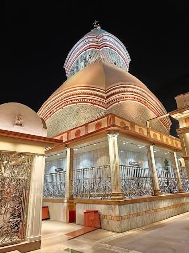 An illuminated temple entrance beneath tiered domes