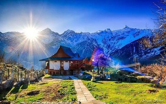 A small temple at a viewpoint beneath snow-covered peaks