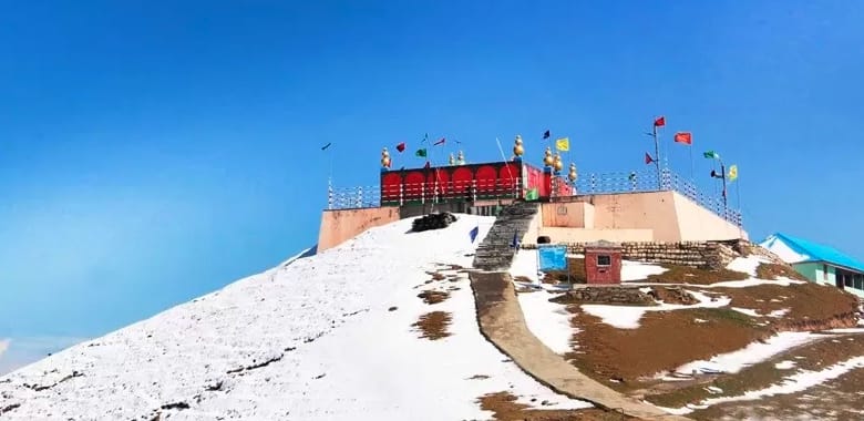 A hilltop temple above stone steps and patches of snow