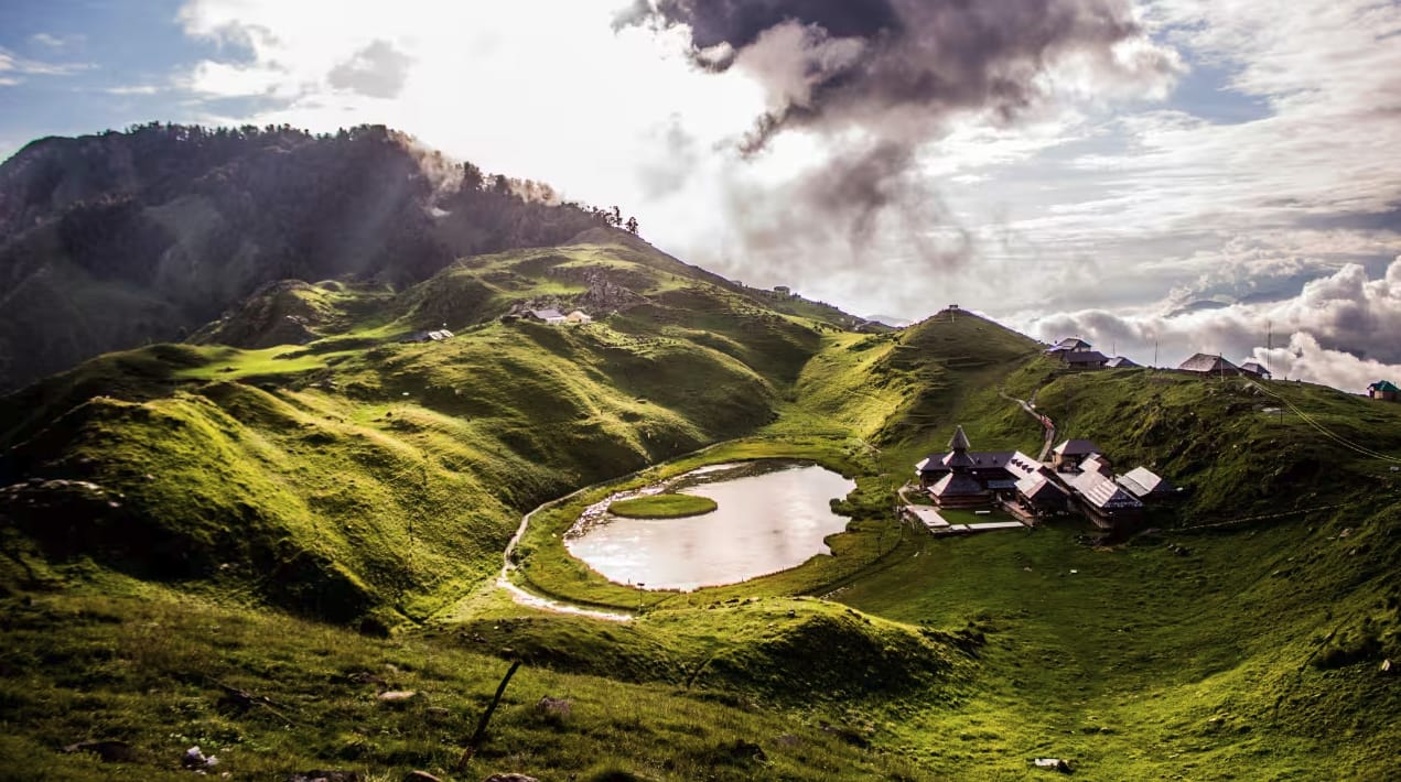 A small lake nestled among sunlit green ridges