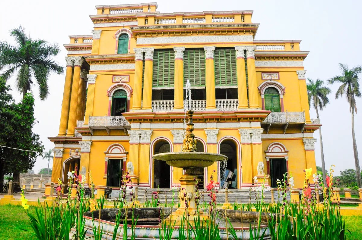 A yellow historic gateway with balconies and arched entrances