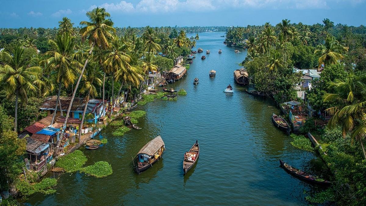 Boats traveling through a palm-lined Kerala canal