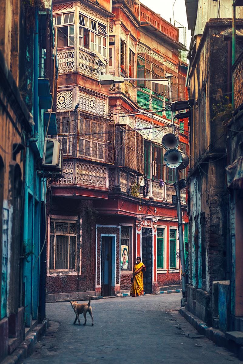 A narrow Kolkata lane lined with colorful old buildings