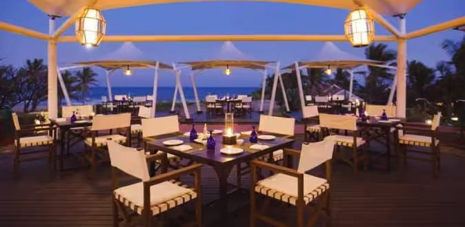 Outdoor dining tables overlooking the sea at dusk