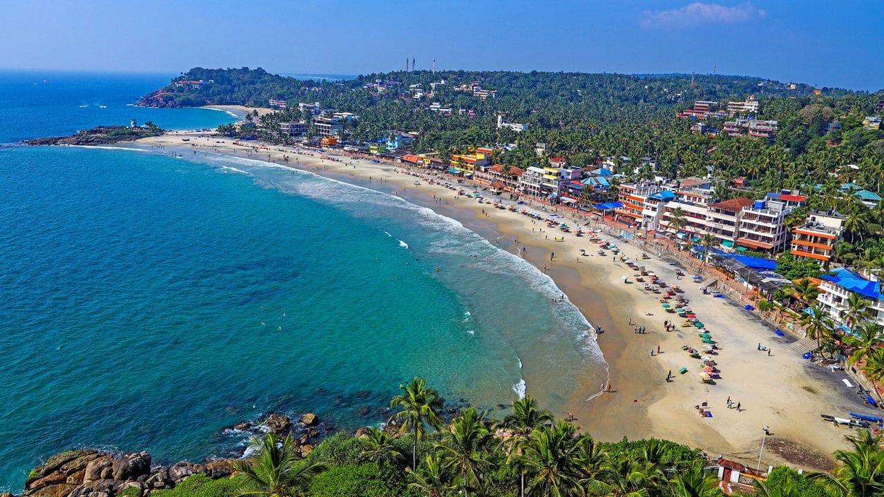 Aerial view of a curving beach and coastal town