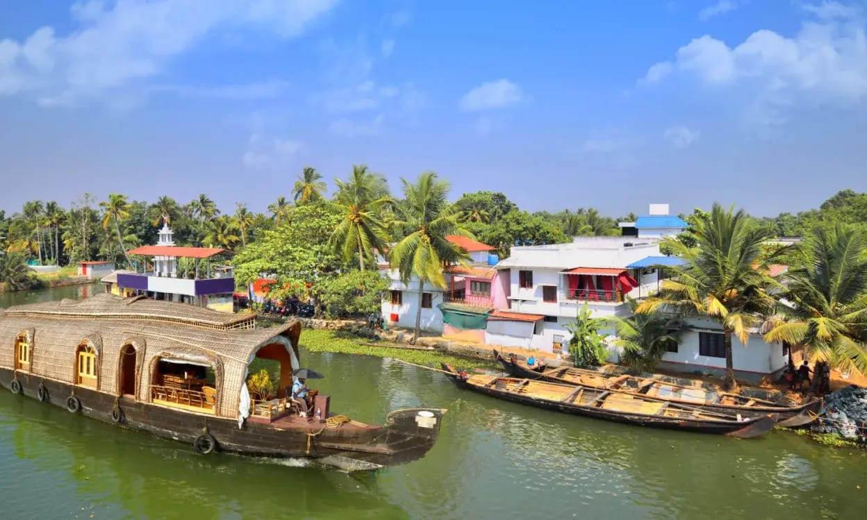 A houseboat passing colorful homes along the water