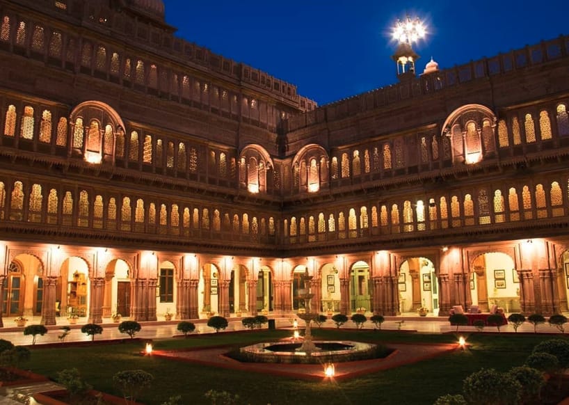An illuminated courtyard enclosed by arched galleries