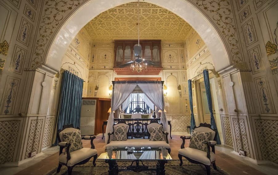 A dining and sitting area beneath a carved stone arch
