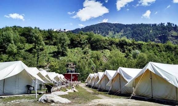 Rows of white canvas tents in a green clearing