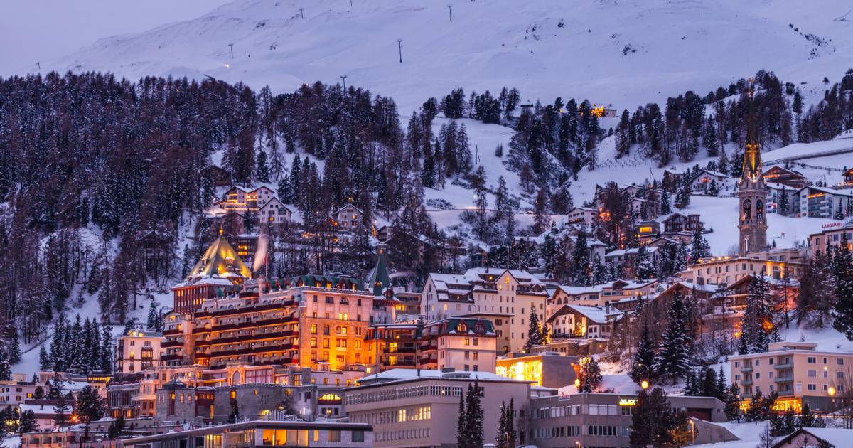 A snow-covered hillside town illuminated at dusk