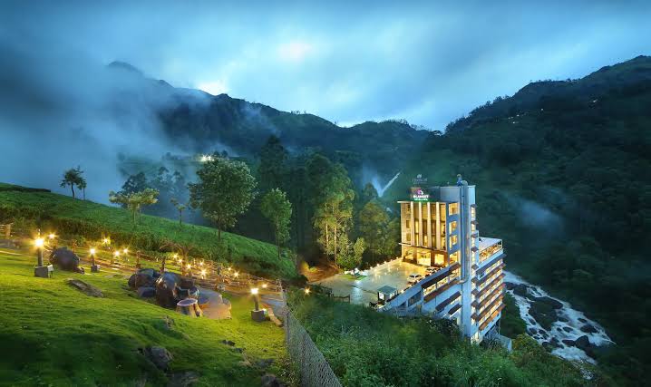 A hillside resort and pool beside a misty river