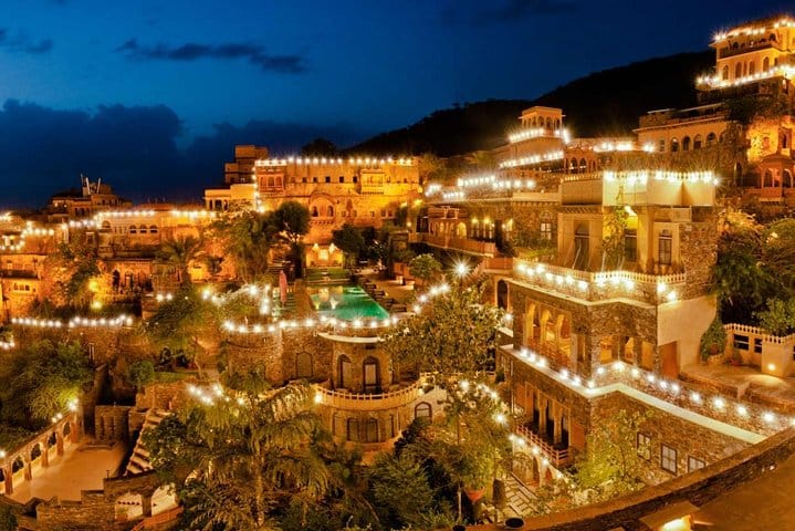 A hillside fort hotel glowing with lights at night