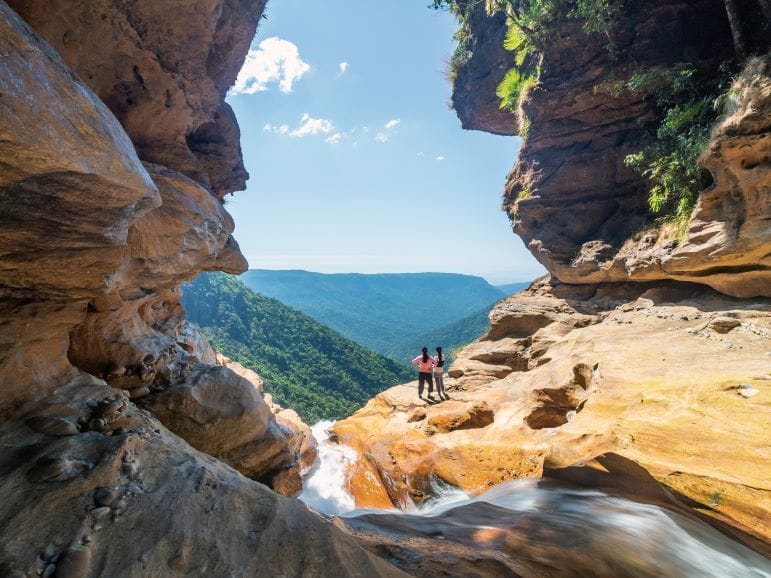 Visitors exploring a rocky opening overlooking the hills
