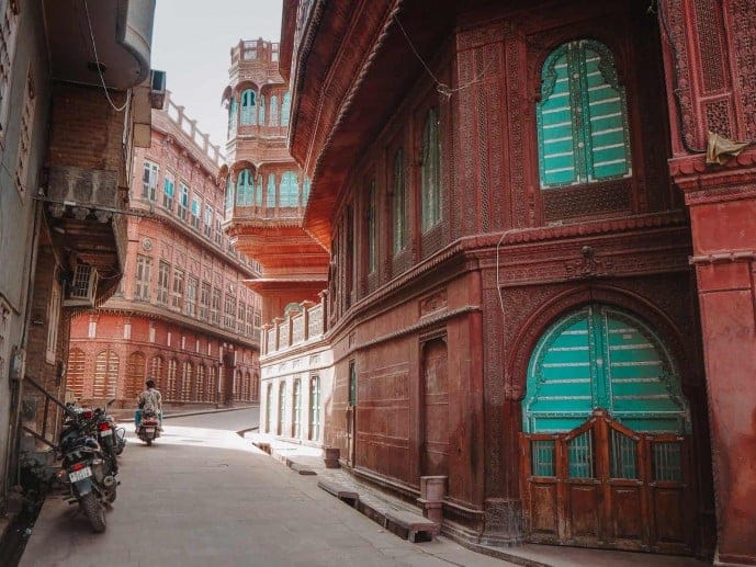 A narrow passage between red sandstone palace buildings